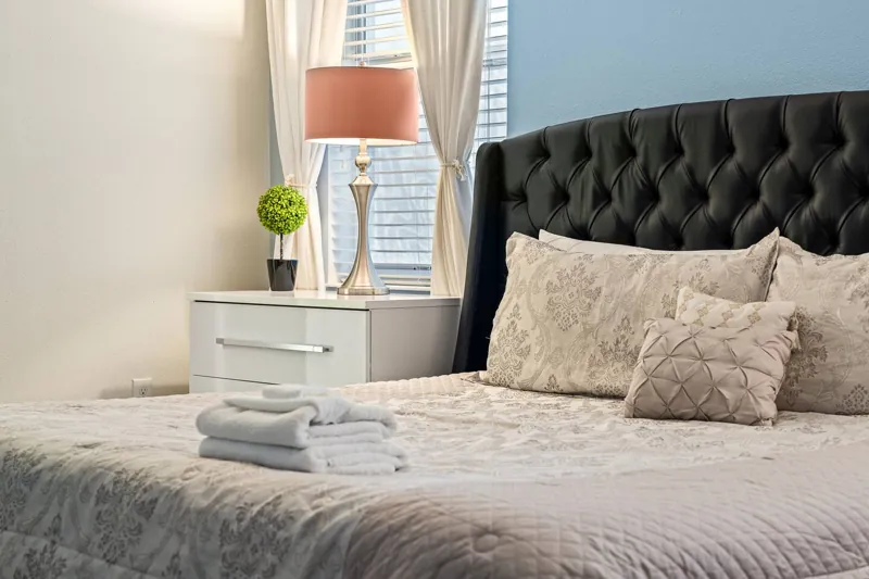 Bedroom with a dark tufted headboard