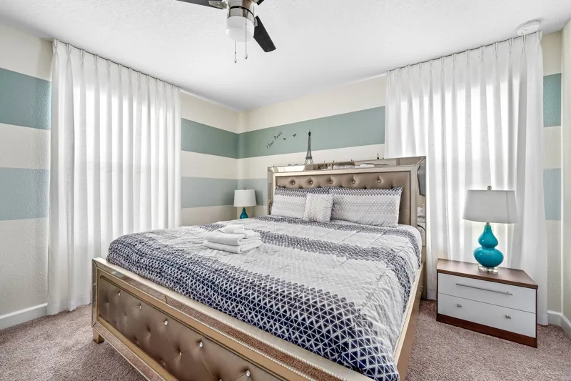 Bedroom with striped bedding and pale blue walls